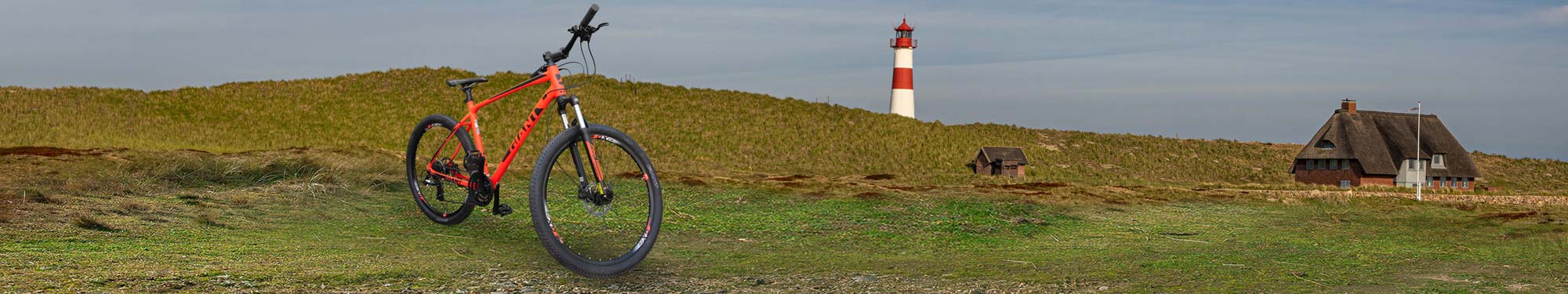 Mountainbike  vor Dünen mit Leuchtturm auf Sylt